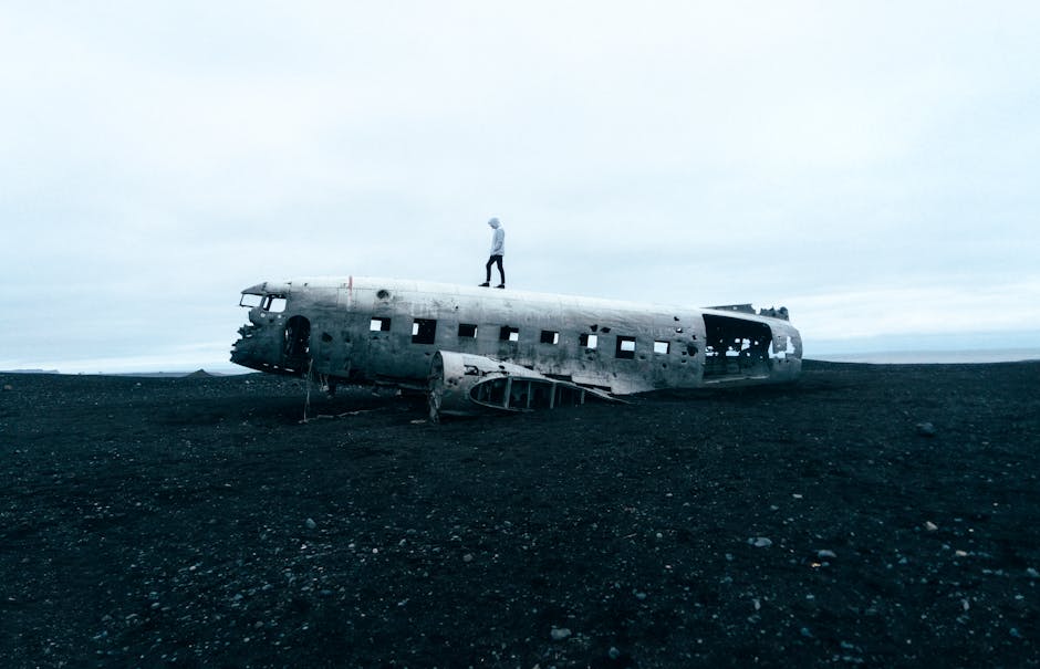 A person standing on a plane wreck symbolizing recovery and resilience